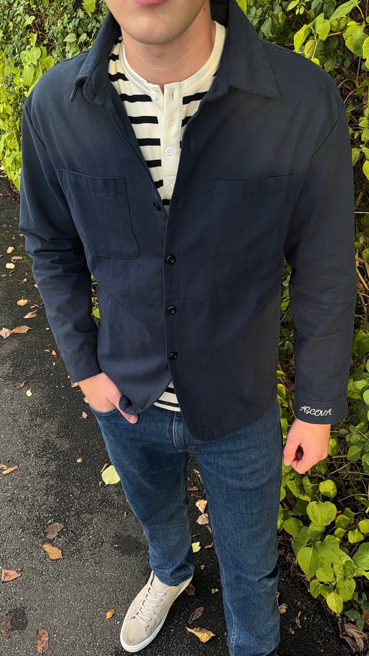 Navy Overshirt båret åpen over stripete henley, hendene i lommene